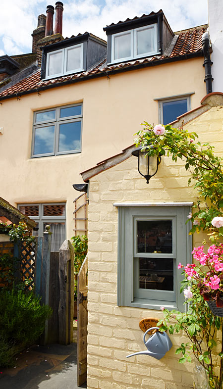 View of Wynd Holiday cottage in Whitby from the terrace with the harbour, sea and abbey views behind the photographer