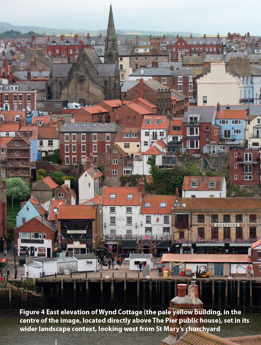ure 4 East elevation of Wynd Cottage (the pale yellow building, in the centre of the image, located directly above The Pier public house), set in its wider landscape context, looking west from St Mary’s churchyard