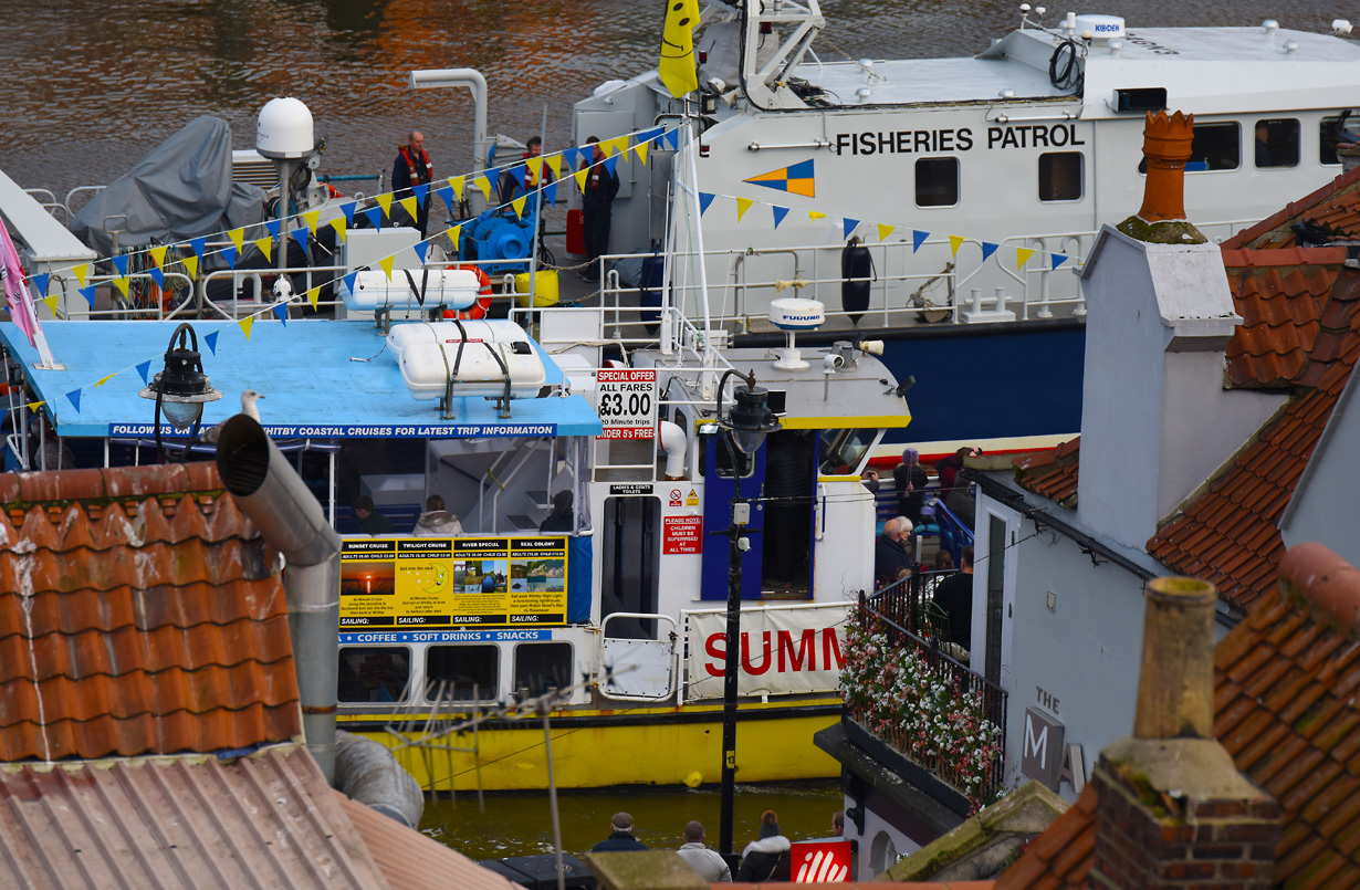 Boats floating past roof tops viewed from the terrace at one of Whitbys finest holiday cottages