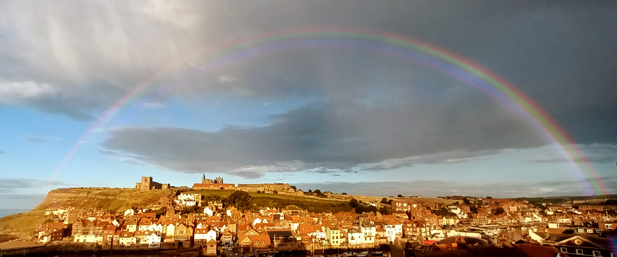 Rainbow arching over Whitby Abbey and church Whitby holiday cottages with views